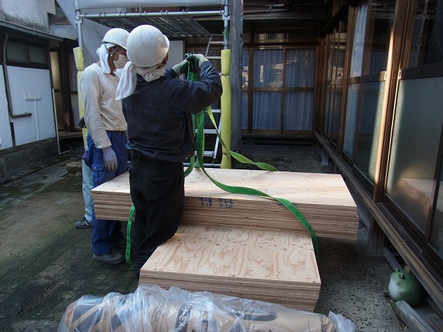 ベニヤ板をクレーンで荷揚げ